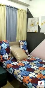 马尼拉Amaze365 Holiday Homes Condotel at Trees Residence Fairview的一间卧室配有一张带五颜六色棉被的床