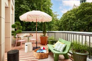 第戎Mama Shelter Dijon的庭院配有遮阳伞、椅子和桌子。