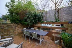 伦敦The St. Lukes Garden Place - Spacious 4BDR House with Garden and Terrace的一个带桌椅和围栏的庭院