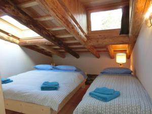 科尔蒂纳丹佩佐CORTINA LODGE的木天花板客房的两张单人床