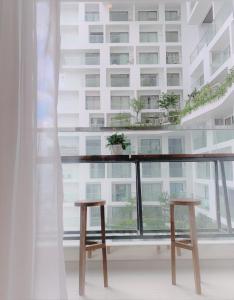 绥和市Apec mandala new Phú yên的大楼前阳台配有2张木凳