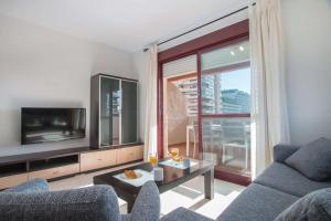 卡尔佩Apartamento Coral Beach - PlusHolidays的带沙发和电视的客厅