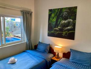暹粒Lotus Haven Villa的一间卧室配有两张床,画着佛陀
