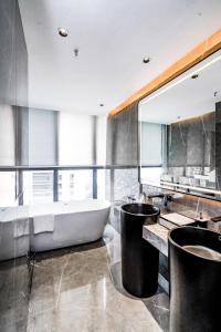 泸州云慕.MAX设计师酒店的一间带浴缸和大镜子的浴室