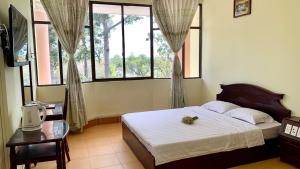 槟知雄王酒店 的一间卧室设有一张床和两个窗户。