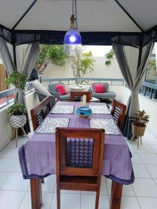 迪拜Jumeirah Beach Villa的阳台上的一张桌子和紫色的桌布