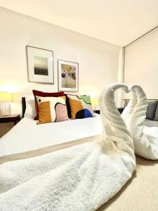 伦敦kings cross St Pancras luxury apt的一间卧室配有一张带两只天鹅的毛巾床