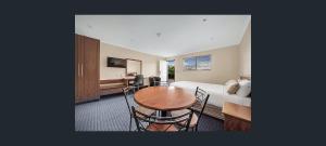 格拉德斯通格拉德斯通公寓式酒店的客厅配有桌子和床。