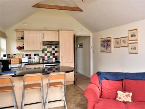 伊尔明顿2 Bed in Stratford-upon-Avon CC025的一间带红色沙发的客厅和一间厨房