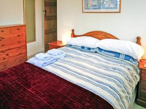 伊尔明顿2 Bed in Stratford-upon-Avon CC025的一间卧室配有一张带木制床头板和枕头的床。