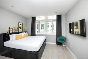 利物浦Staycity Aparthotels Liverpool Waterfront的一间卧室配有一张大床和一张绿色椅子