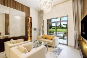 迪拜Livbnb - 2BR close to Souk Mall and Burj Al Arab的客厅配有2张白色沙发和吊灯。