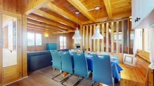 韦松纳Fontannets COSY & MOUNTAIN chalets的一间带桌子和蓝色椅子的用餐室