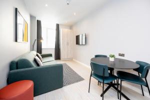 利物浦Staycity Aparthotels Liverpool Waterfront的客厅配有沙发和桌椅