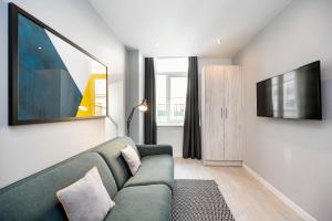 利物浦Staycity Aparthotels Liverpool Waterfront的客厅配有绿色沙发和电视