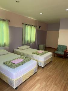 Ban Cha-omAmano green resort的带绿窗的客房内的两张床