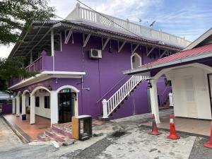 瓜埠OYO 90907 Brick Cottage Homes的紫色的建筑,上面设有阳台
