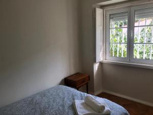 里斯本Casa da Branca Gonta Colaço的一间卧室设有一张床和一个窗口