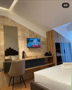 东吉托伊Hotel Comfort & Villas的一间卧室配有一张床,墙上配有电视