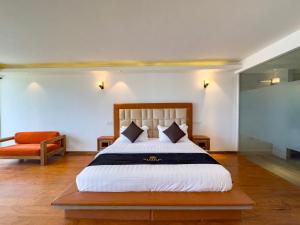 平谷Mazarine Surf Suites Hiriketiya的一间卧室配有一张大床和一把椅子