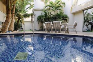 延布ريفان لبيوت الضيافة خاصة的一座带椅子和树木的酒店游泳池