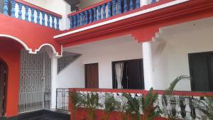 卡纳科纳INAS Guest House的拥有红色和白色墙壁和蓝色楼梯的房子