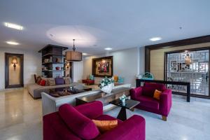 科纳克勒Palmeras Beach Hotel Ultra All Inclusive的客厅配有紫色椅子和沙发