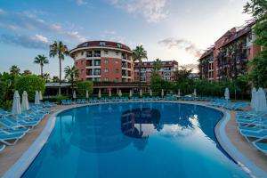 科纳克勒Palmeras Beach Hotel Ultra All Inclusive的酒店前方的游泳池配有椅子和遮阳伞