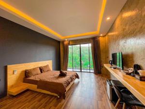 Ban Song Phi NongJK Riverview Resort的一间卧室设有一张床、一台电视和一个窗口。