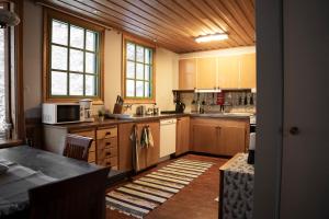 上托尔内奥Bed & Breakfast Willa Armas的一个带木制橱柜和桌子的大厨房