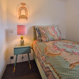 拉纳肯Bungalow AMNIS的一间卧室配有一张床和一张带台灯的桌子
