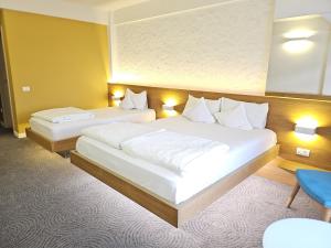 蒂米什瓦拉席尔瓦酒店的两张床位于带灯光的酒店客房