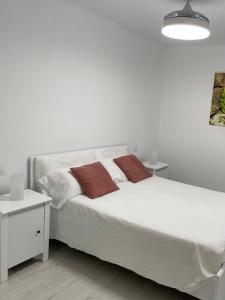 ArguineguínPURA VIDA的卧室内的一张带两个枕头的白色床