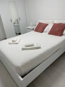ArguineguínPURA VIDA的一张白色的床,上面有两条毛巾