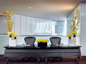 芝加哥芝加哥壮丽大道索菲特酒店的一张桌子,上面有三把椅子和黄色的花