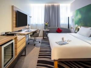 维也纳维也纳诺富特酒店的酒店客房设有一张床、一张书桌和一台电视机。