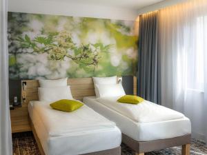 维也纳Novotel Suites Wien City Donau的墙上画画的房间里设有两张床