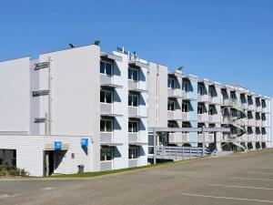 尚尼耶ibis budget Angoulême Nord的一座大型白色公寓大楼,设有停车场