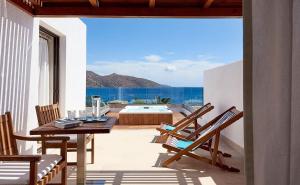 阿基欧斯尼古拉斯圣尼古拉斯湾度假酒店及别墅的一个带桌椅的庭院和一个游泳池