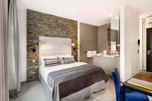 柏林柏林-米特鲁卡斯11号酒店的一间卧室设有一张床和砖墙