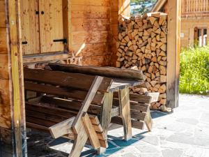 图拉彻霍赫Alpin-Hütten auf der Turracherhöhe - Haus Fuchs by S4Y的木凳,旁边堆着一堆木柴