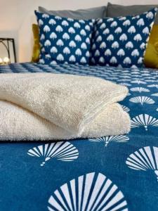 圣若瑟La villa Loca Reunion的一张带蓝色和白色床单及枕头的床