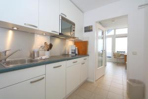 韦斯特兰Haus am Meer14 - App. 159的厨房配有白色橱柜和水槽
