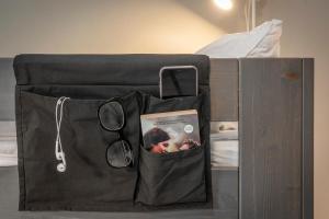 哥德堡哥德堡酒店的床上的黑包,带书和眼镜