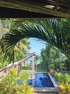 卢纳将军城Daluyong Beach Resort的棕榈树花园中的游泳池