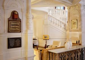 伦敦圣尔敏酒店 - 傲途格精选酒店的大堂设有楼梯和桌子上的花瓶