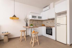 库卡里8MOONS Elegant Apartments的白色的厨房配有凳子和白色冰箱