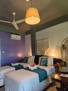 卢纳将军城Daluyong Beach Resort的紫色墙壁客房的两张床