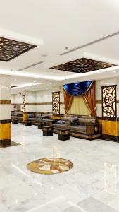 麦加فندق انوار المشاعرالفندقية的大型大堂配有沙发,地板上设有时钟