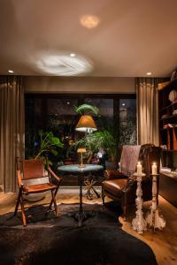布拉索夫Le Petit Chalet的客厅配有两把椅子、一张桌子和一盏灯
